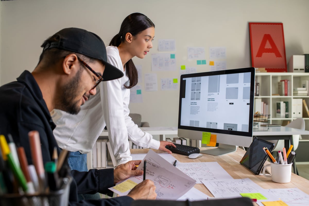 Designers discussing website wireframes and prototypes